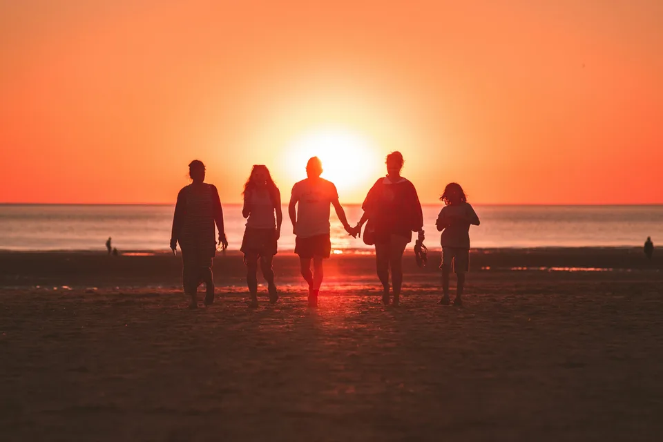 A family silhouetted against the setting sun
