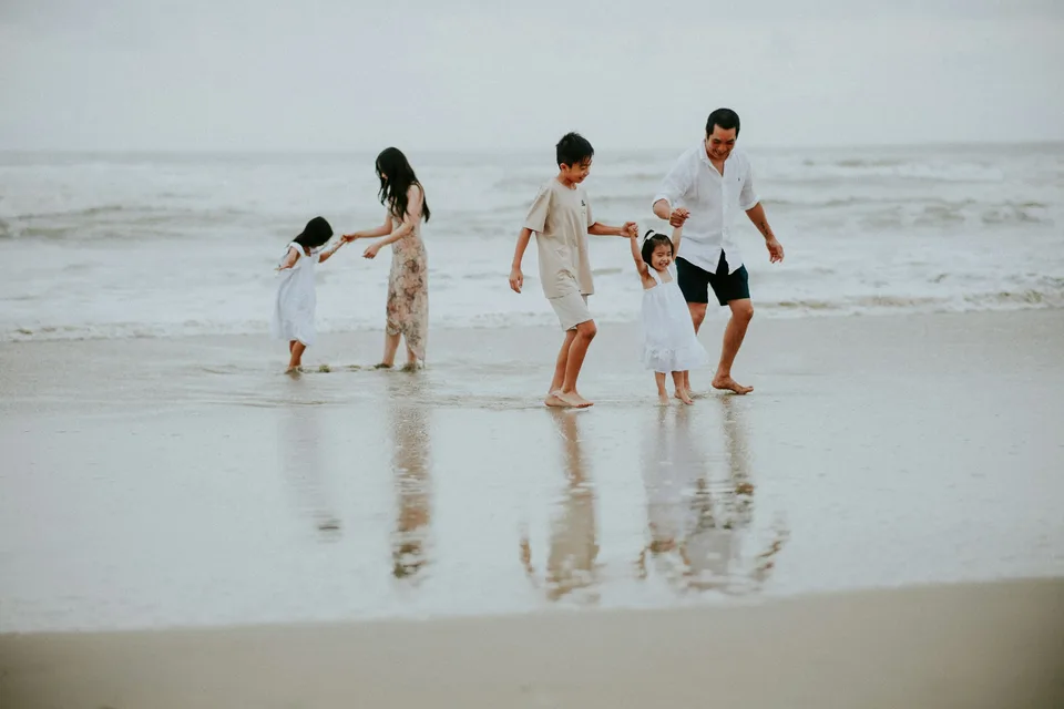 A family laughing together at the water's edge