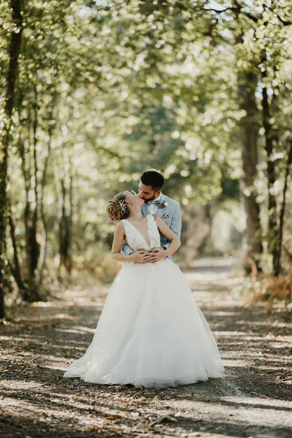 A couple embracing in a sunlit forest